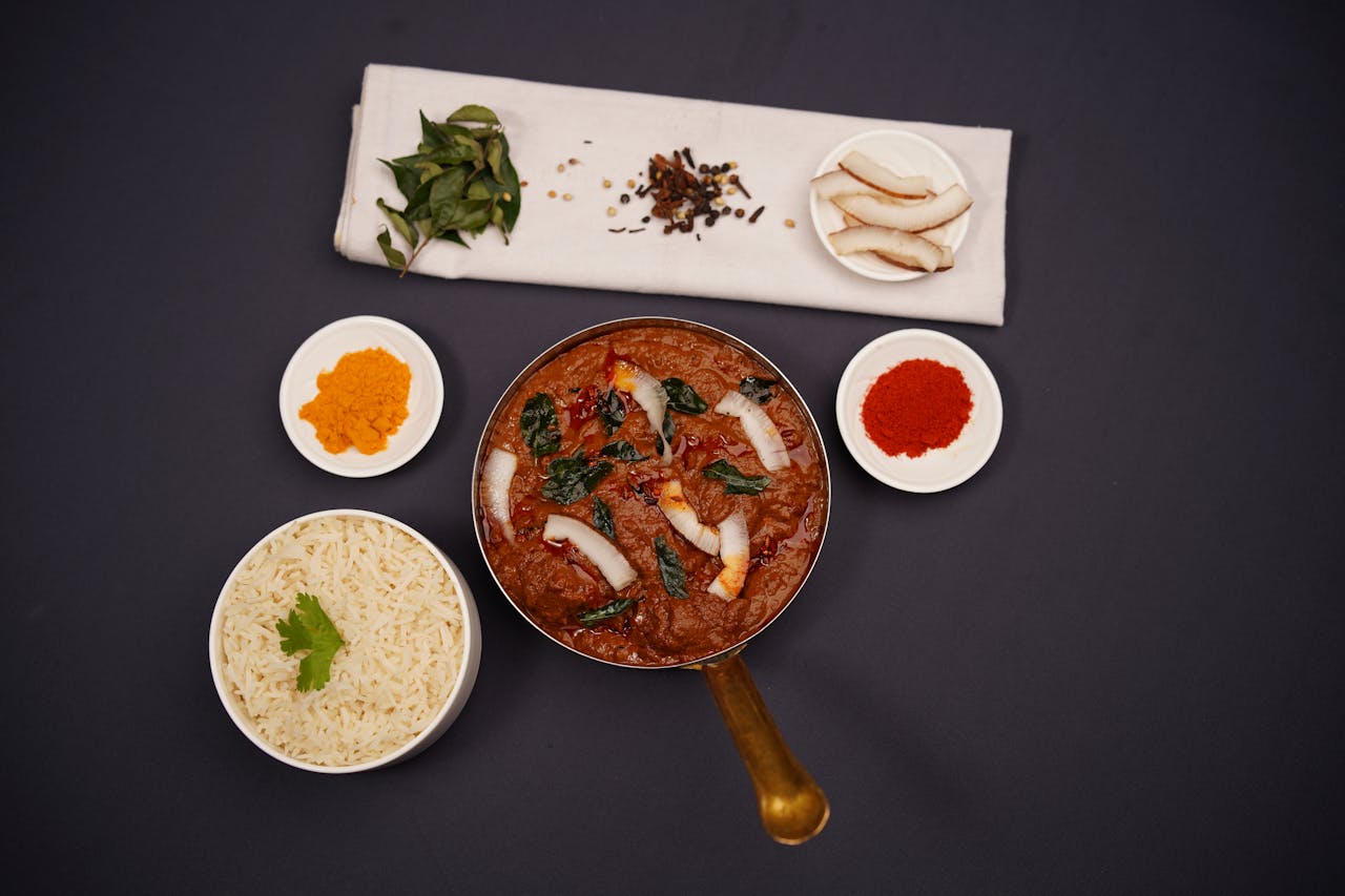 why-choose-us Top view of a traditional Indian curry served with rice and spices on a dark background.