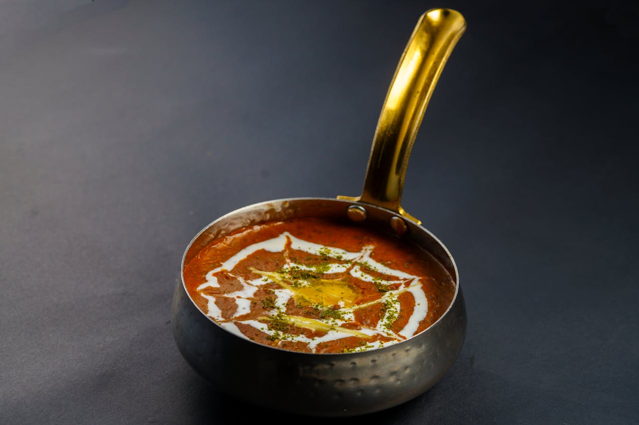 about-01 Rich and creamy dal makhani served hot in a traditional Indian pan. Perfect for food lovers.
